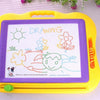 A yellow magnetic drawing board for kids with a purple surface showing various drawings like a sun, flowers, and a face.