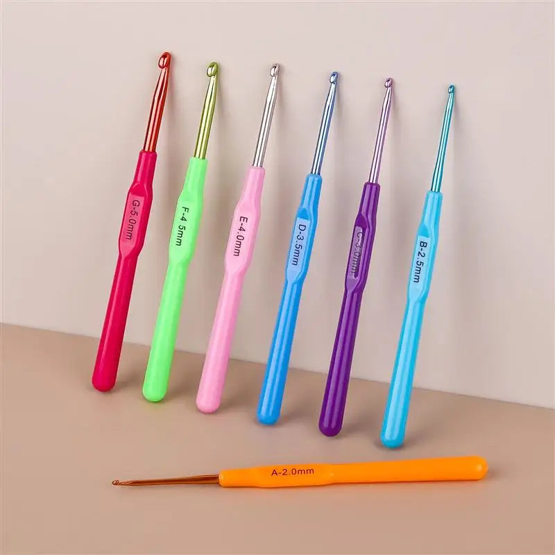 A set of seven aluminum alloy crochet hooks in various colors and sizes displayed on a neutral background.