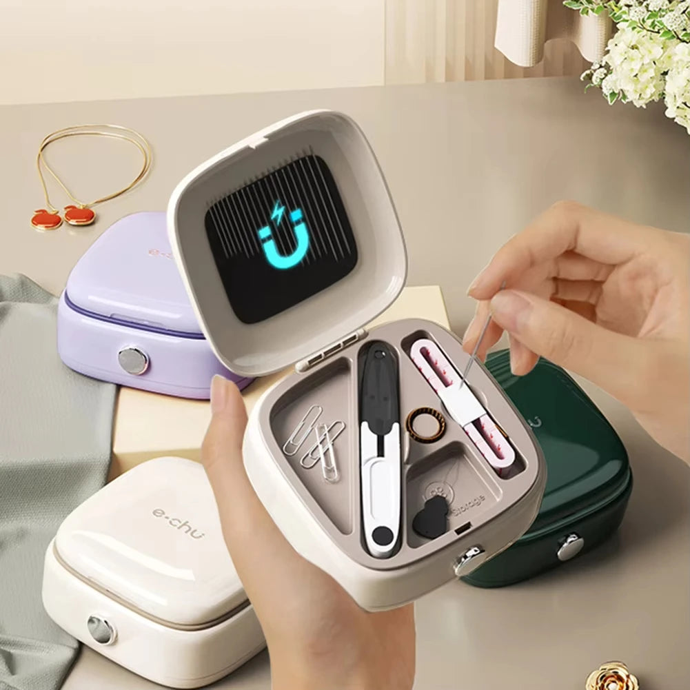 A hand holds an open compact magnetic sewing kit with various needles and thread colors displayed inside.