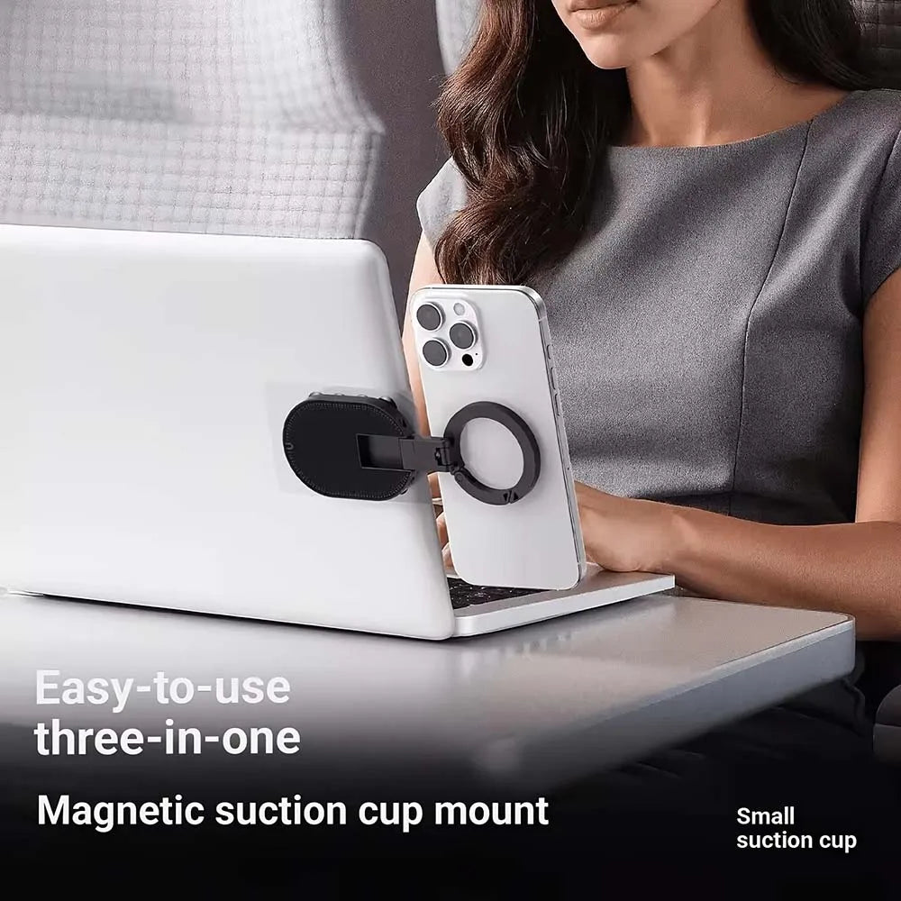 A woman uses a magnetic suction cup mount to hold a smartphone on a laptop.