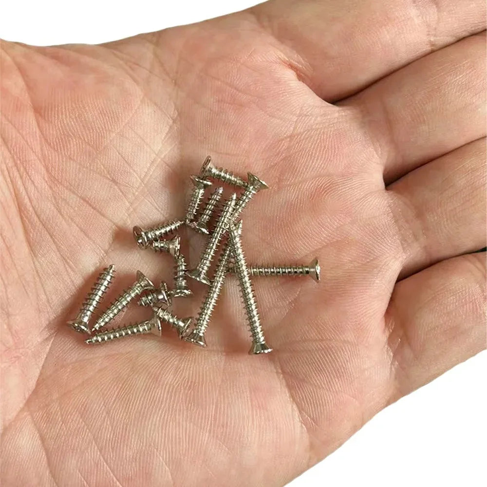 A pile of M3 stainless steel self-tapping screws is held in a person's hand.