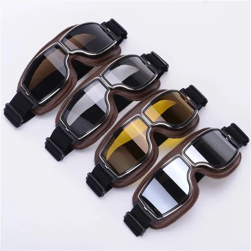 A pair of brown leather retro foldable motorcycle goggles with dark tinted lenses and black straps.