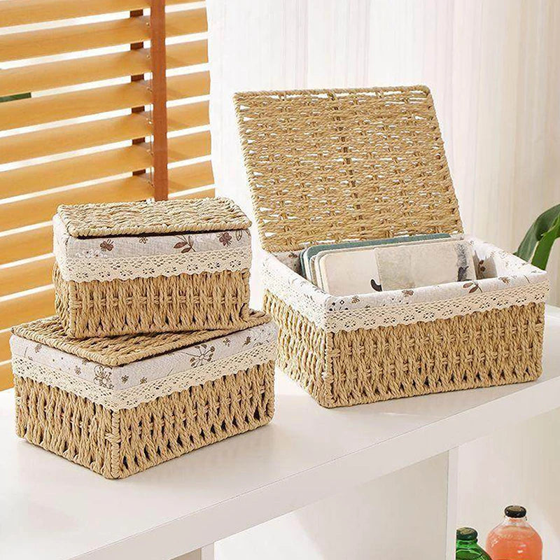 A stack of natural woven rattan storage baskets and a larger basket on a white table.