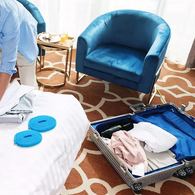 A portable nylon travel clothesline with hooks is shown next to a blue velvet armchair and a white bed.