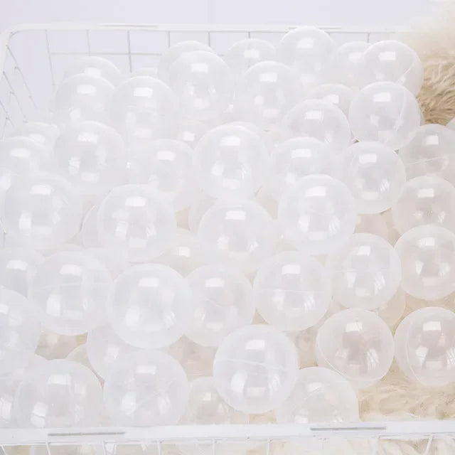 A white plastic basket filled with a large quantity of clear, round, bubble-like balls.