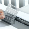 A hand applies a clear, self-adhesive window screen repair patch onto a window frame.