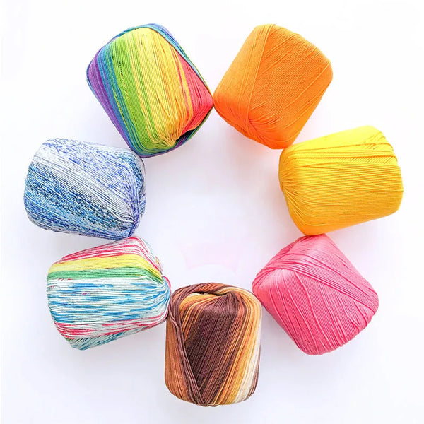 A collection of brightly colored pearl rainbow gradient cotton yarn skeins arranged in a circle.