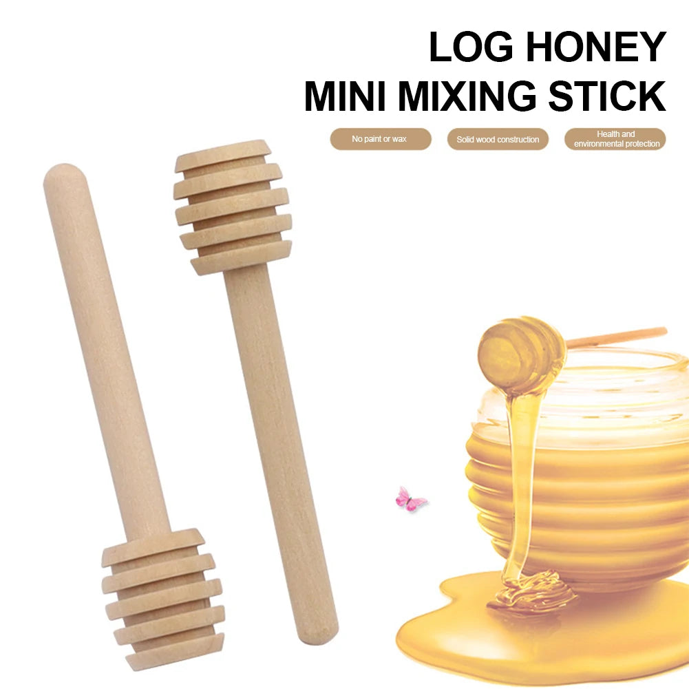 A wooden honey dipper stick and a jar of golden honey on a yellow surface.