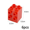 A red plastic building block set with six circular studs on the top surface.