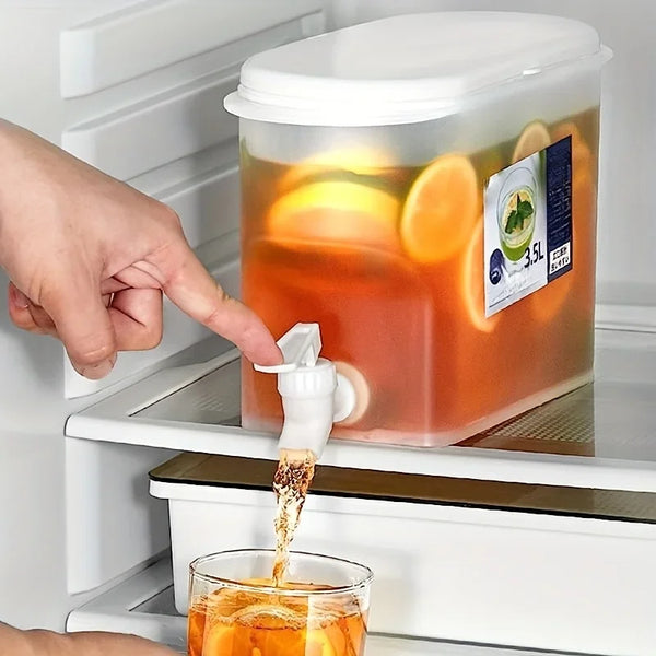 Una mano vierte jugo de un dispensador grande en un vaso usando un gotero.