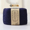 A skein of dark indigo bamboo fiber yarn labeled as Bamboo fiber for knitting and crochet.