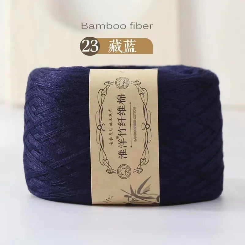 A skein of dark indigo bamboo fiber yarn labeled as Bamboo fiber for knitting and crochet.