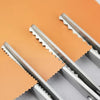 Silver scalloped pinking shears lying on a gray surface.
