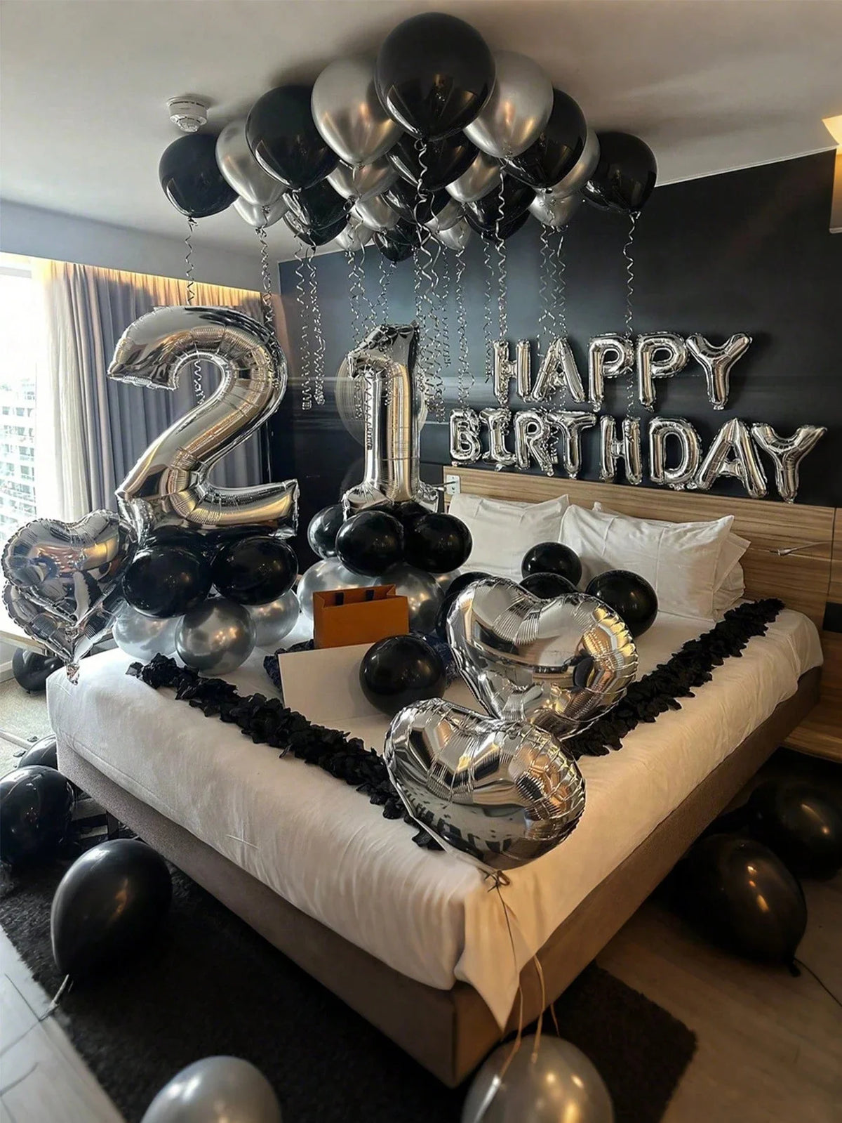 Silber- und schwarze Ballons schreiben 'Happy Birthday' mit großen Ziffern 2 und 1