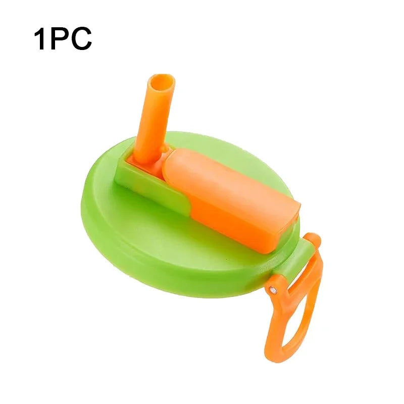 A green silicone can lid with an orange straw, designed for reusable use.