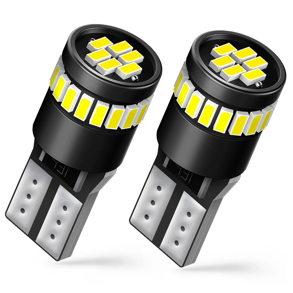 A pair of black LED light bulbs with yellow illumination and metal contacts are shown.