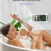 A woman relaxes in a bathtub while using a shower phone holder to watch content.