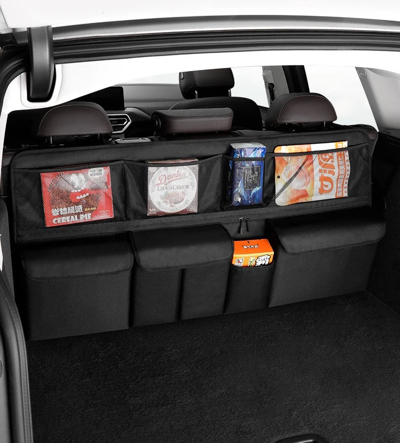Interior view of a car showing a black foldable trunk organizer with various storage compartments and items.