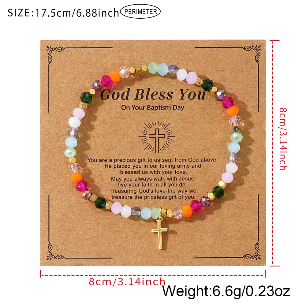 A gold cross-shaped crystal bead bracelet with various colored stones, presented on brown kraft paper.