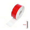 A roll of red and white self-adhesive car door edge protector strip with a measuring scale.