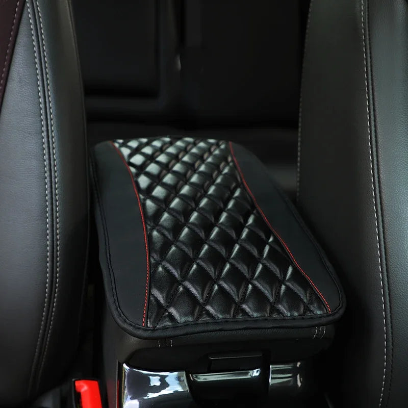 Black leather car armrest cover with a quilted storage pad and chrome lever.