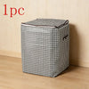 A single foldable quilt storage bag with a black and white houndstooth pattern resting on a wooden floor.
