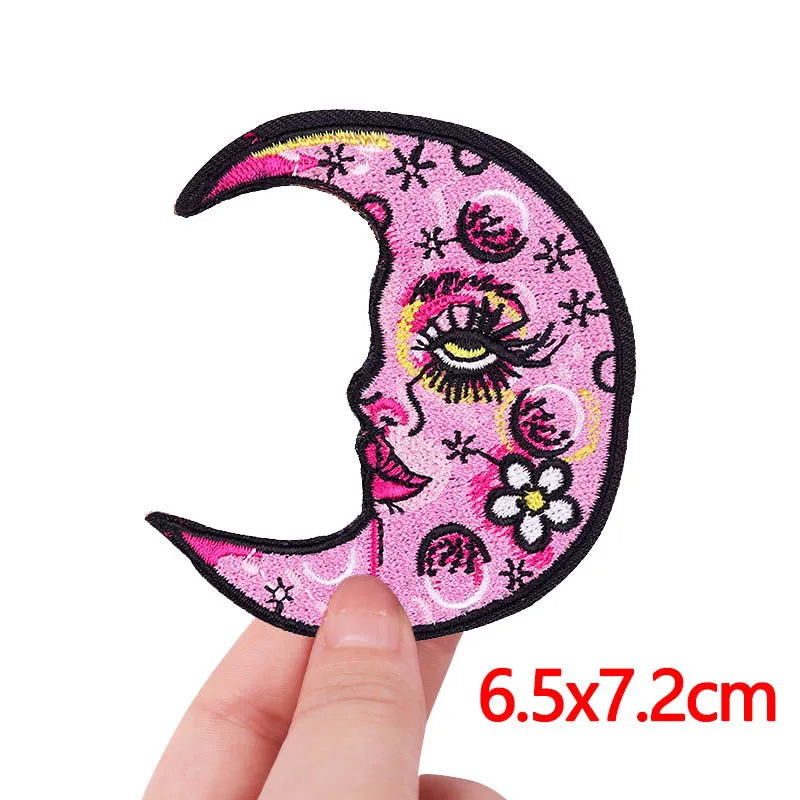 Pink crescent moon embroidery patch featuring a stylized cat face and floral details