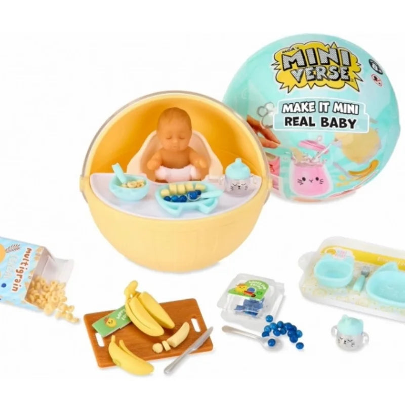 A yellow bowl contains a baby doll and miniature food accessories, next to a packaging box and a Miniverse Real Baby kit.