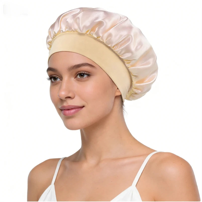 A woman wearing a light pink silk satin sleep bonnet with a wide elastic band.