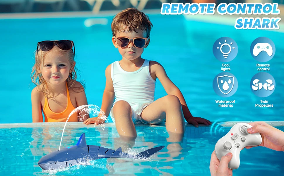A child is holding a remote control shark toy that sprays water in a swimming pool.
