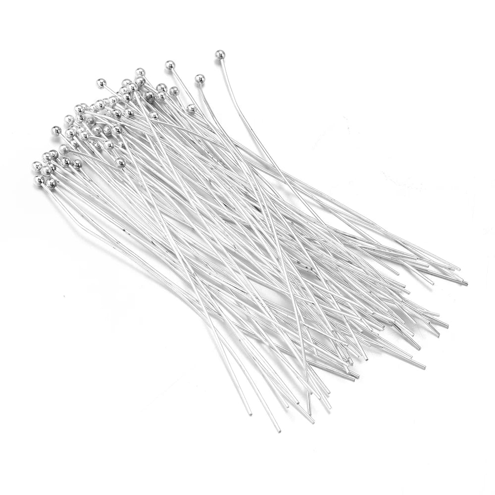 A collection of gold-plated brass ball head pins for jewelry making, arranged in a fan shape.