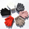 A collection of five plush winter gloves in black, gray, white, pink, and orange colors arranged in a circle on a white backg