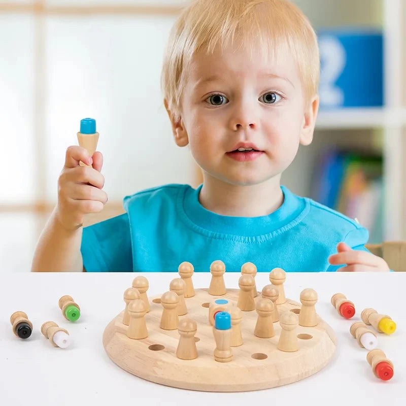 A toddler holds a wooden memory chess game with pieces on a light wood board.