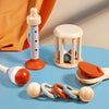 A collection of wooden baby rattles and a wooden teething ring are displayed on a blue surface.