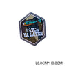 A hexagonal embroidered patch featuring a brightly colored fish above the text YA LATER on a dark background