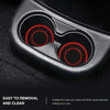 Close-up view of two black silicone coasters with red accents inside a car cup holder