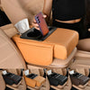 A hand places a smartphone on an orange car armrest cushion with cup holders and storage compartments.