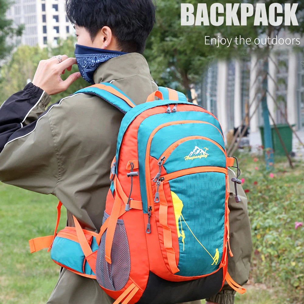 A person wearing a olive green jacket is adjusting an orange and teal backpack outdoors.