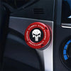A close-up of a red and black rotating protective cover for a car ignition start button.