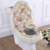 A decorative toilet seat cover set featuring a quilted floral pattern and ruffled fabric.
