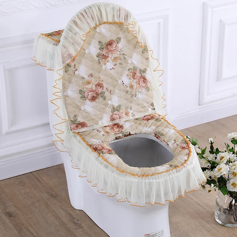 A decorative toilet seat cover set featuring a quilted floral pattern and ruffled fabric.