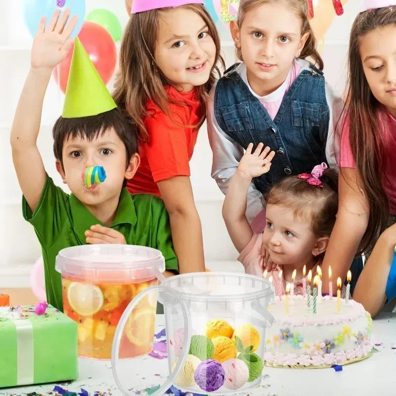 Children celebrating a birthday with a cake and colorful fruit in transparent reusable storage containers