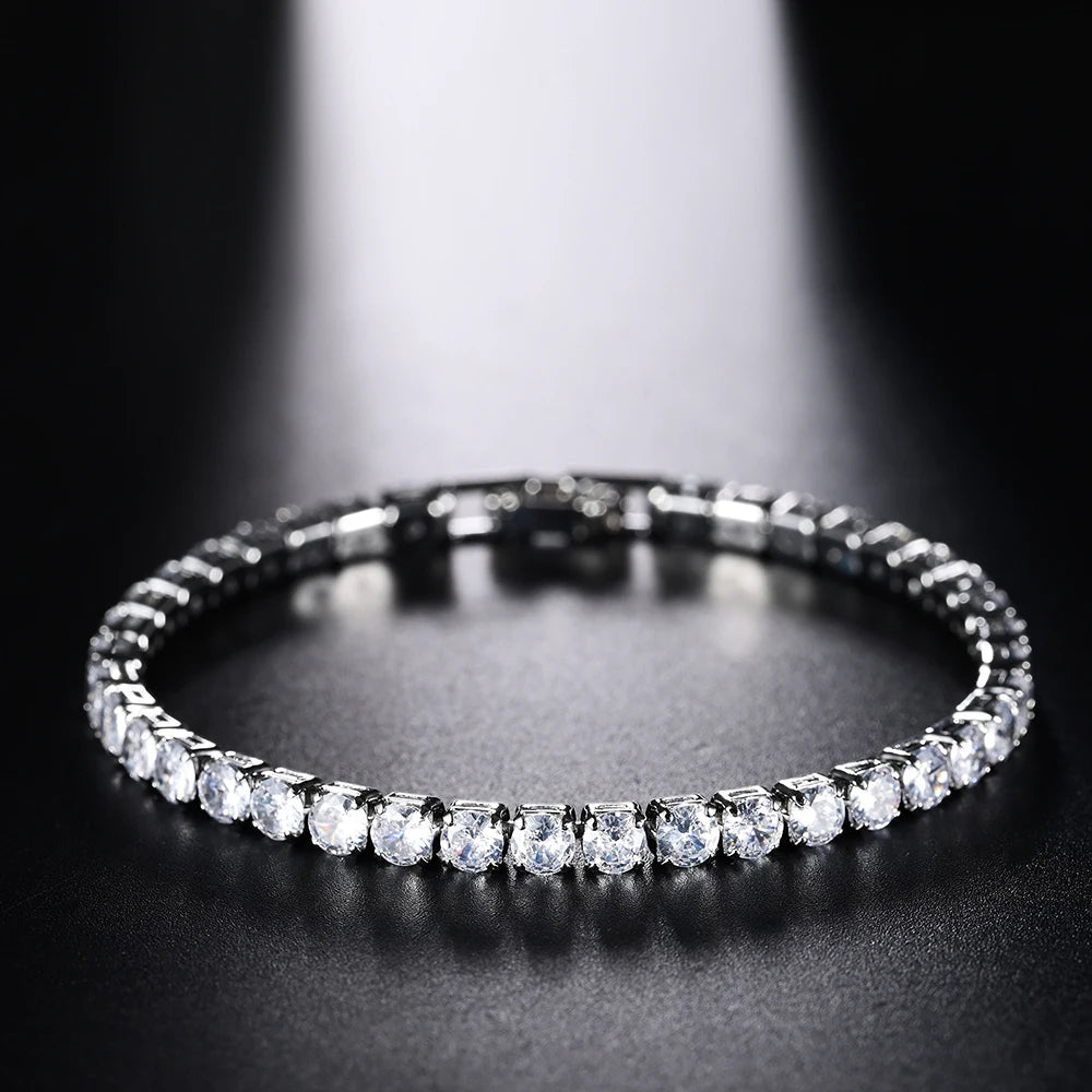 Gros plan d'un bracelet de tennis en diamant avec micro pavés sur une surface sombre.