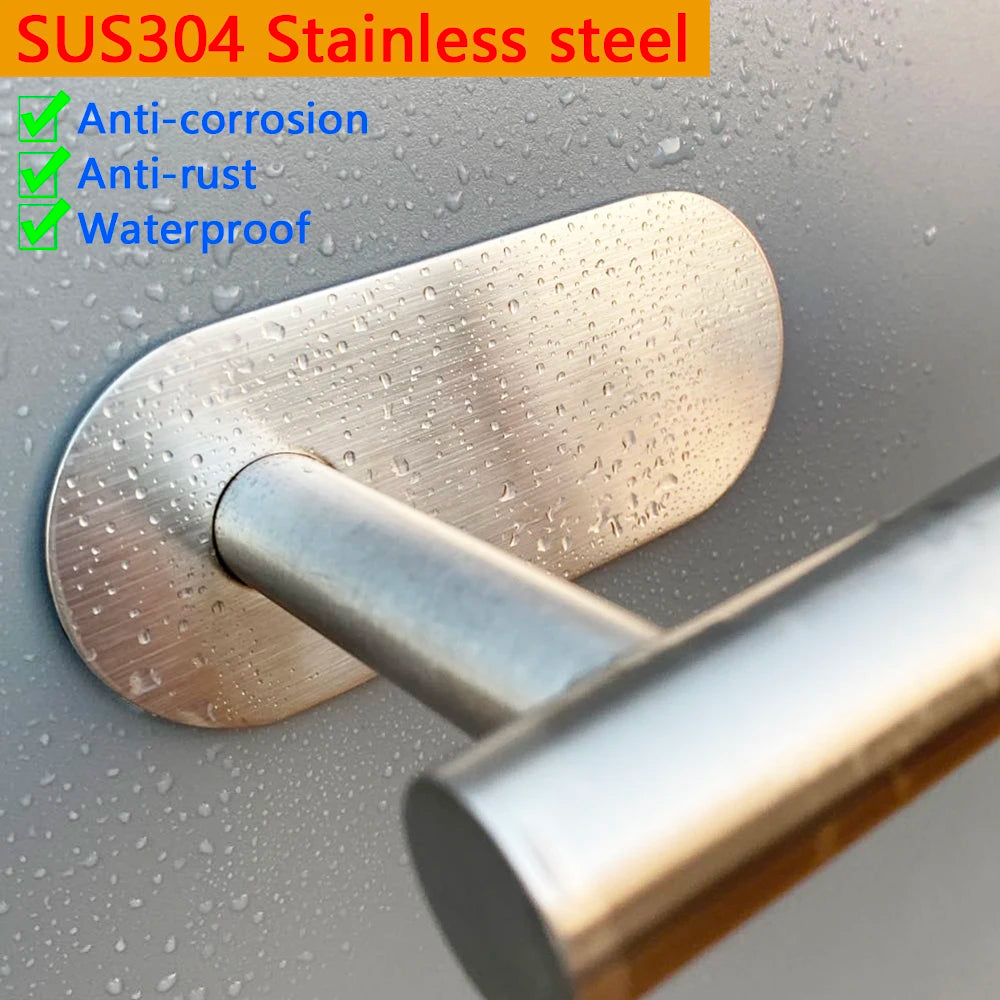 Close-up of a stainless steel adhesive toilet paper rack with a silver handle against a gray background.