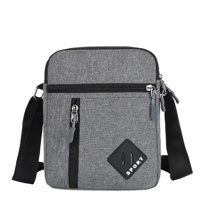 A gray lightweight crossbody sling bag with multiple zip pockets and black adjustable straps.
