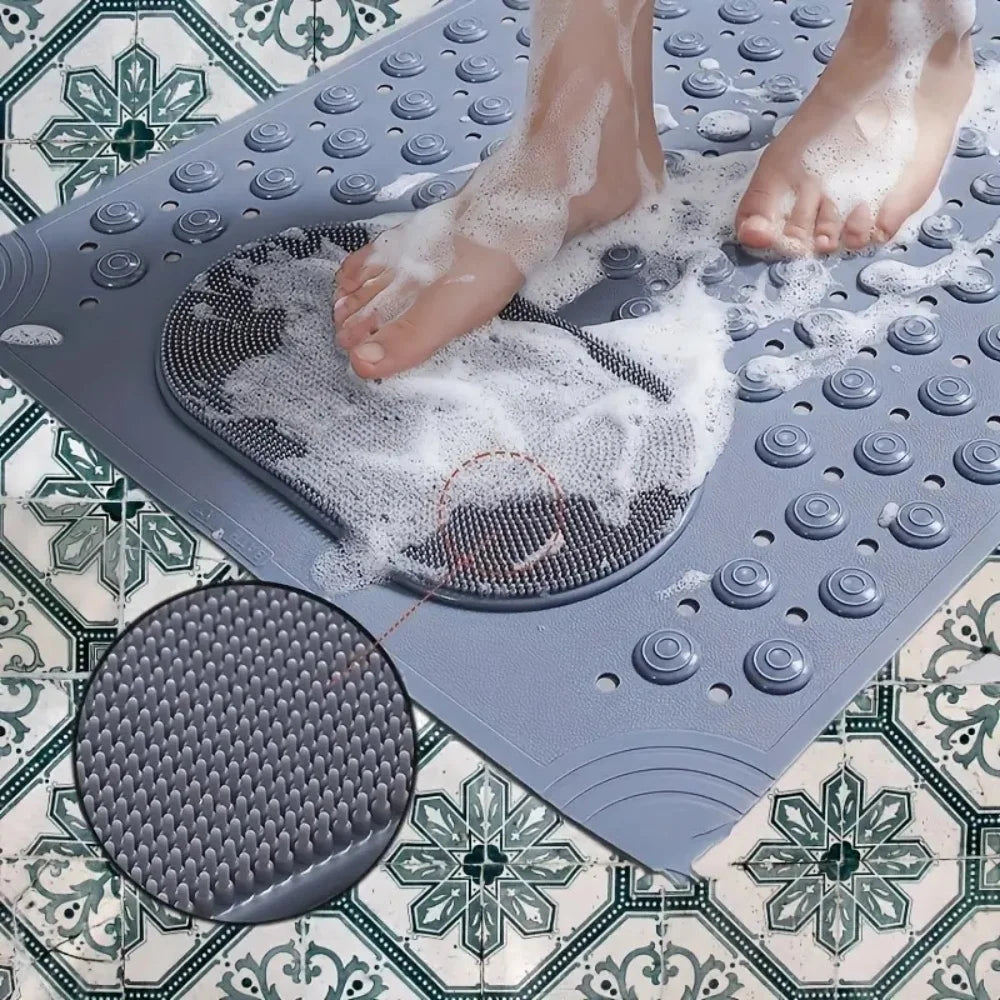 A person's feet are placed on a gray non-slip bath mat with massage nodes, creating foam.
