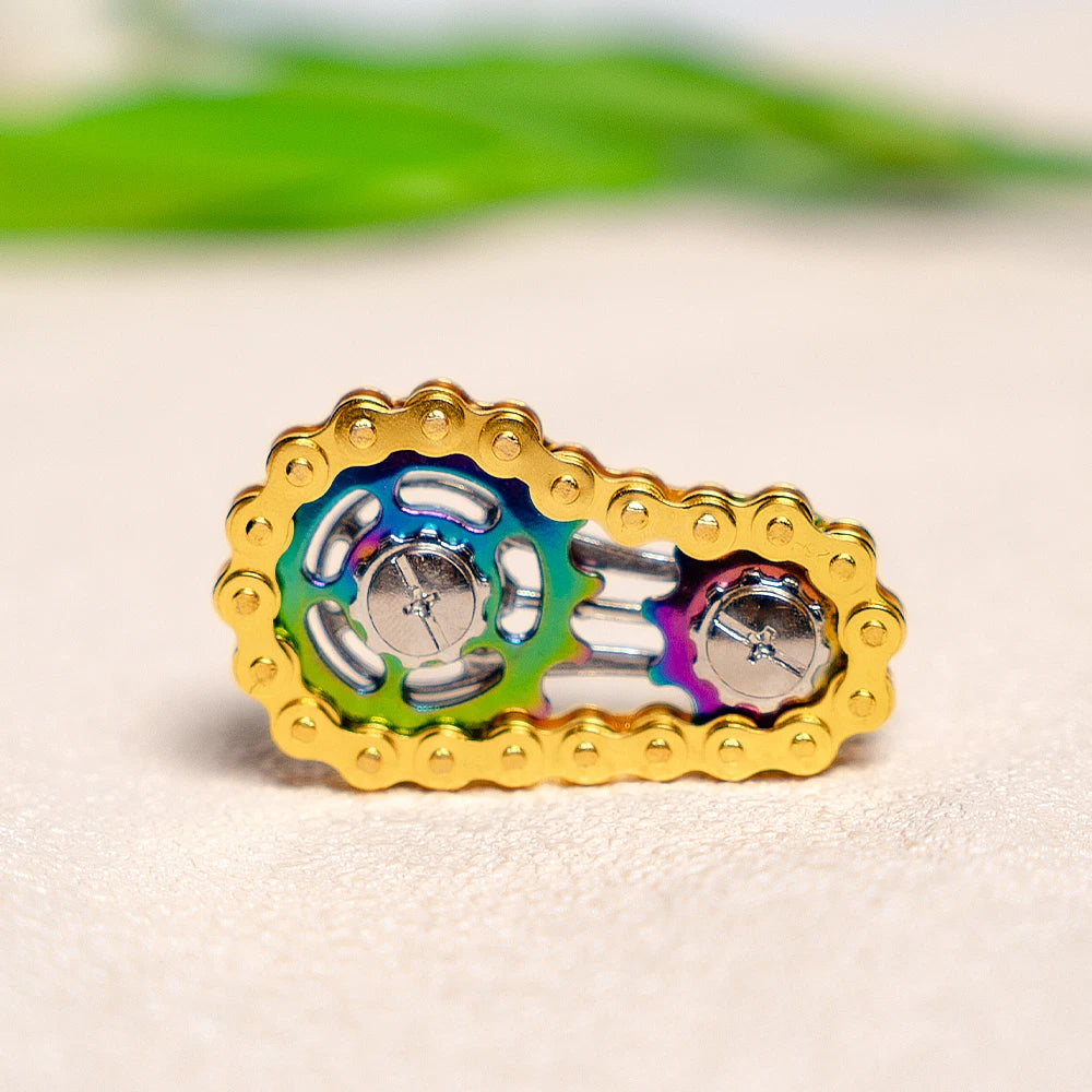 A gold-colored hand spinner featuring an iridescent rainbow effect on the center component.