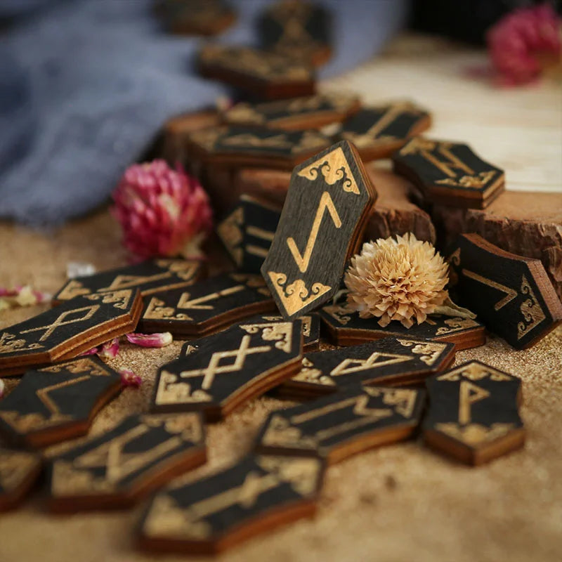 A collection of wooden rune stones and divination tools scattered on a light surface.