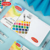 A box of a 36 color watercolor paint set with water brush pens and an open palette shown on a light blue background.