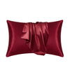 A deep burgundy silky smooth satin pillowcase rolled and displayed against a white background.